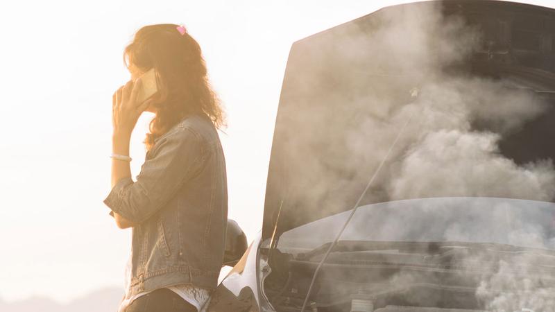 A woman stranded on the side of the road because of a overheated car. She's calling for roadside assistance.